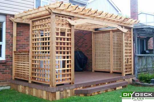 Deck with privacy screens and a decorative pergola.