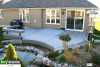 Large single level grey composite deck with a curved face and an integrated bench, attached to a brick house.